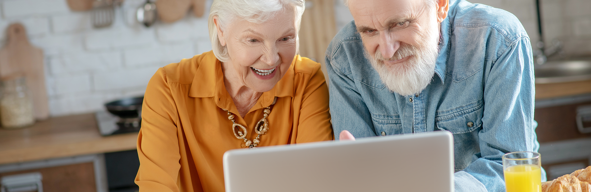 elderly-couple-in -kitchen-purchasing-insurance